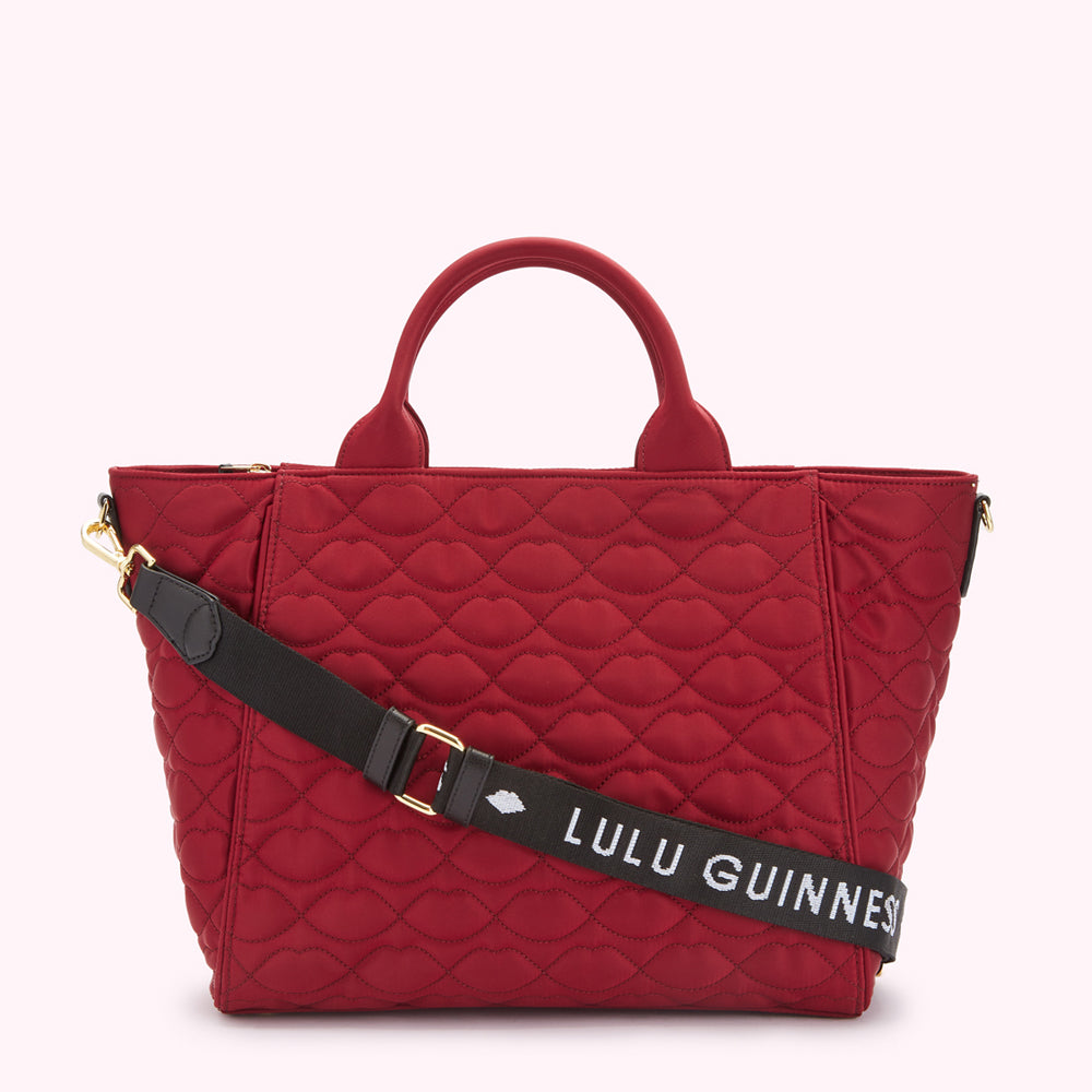 Red quilted Lulu Guinness tote bag with black shoulder strap.