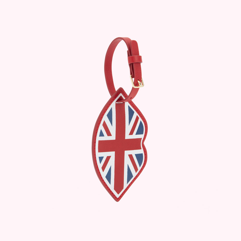 Front image of a red leather lip shaped luggage tag with buckle fastening and a  union jack print.
