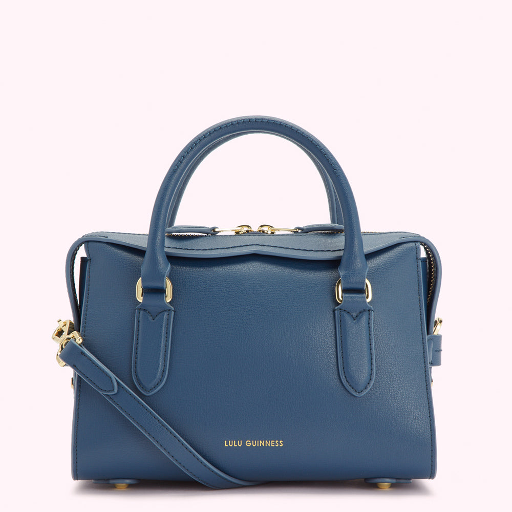 A blue Lulu Guinness leather handbag with gold hardware and a detachable shoulder strap.