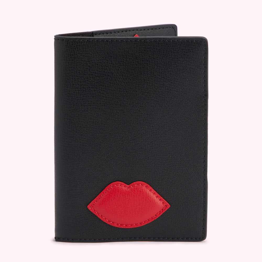 Black leather passport holder with a red lip detail.