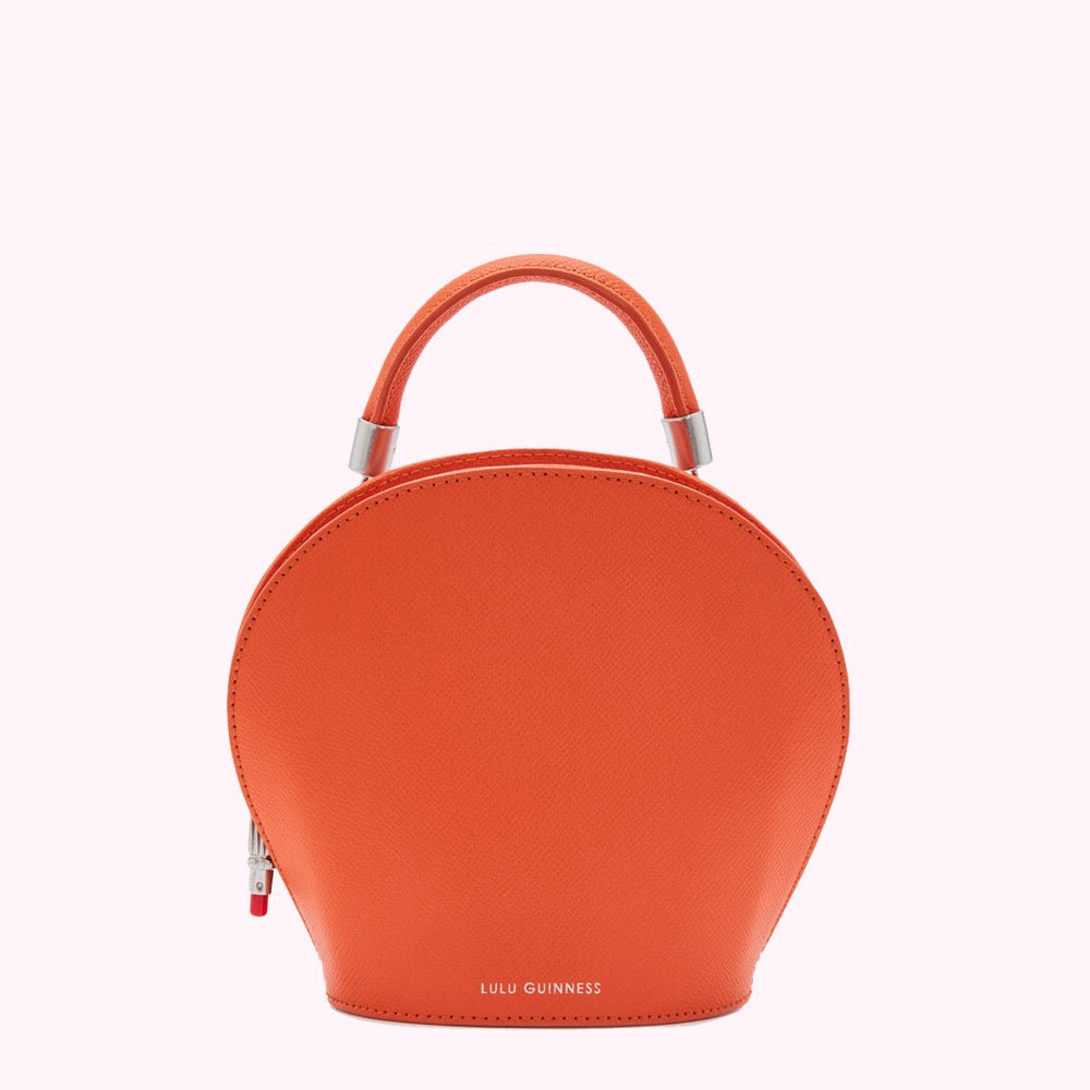 Orange Lulu Guinness half-moon handbag with silver top handle.