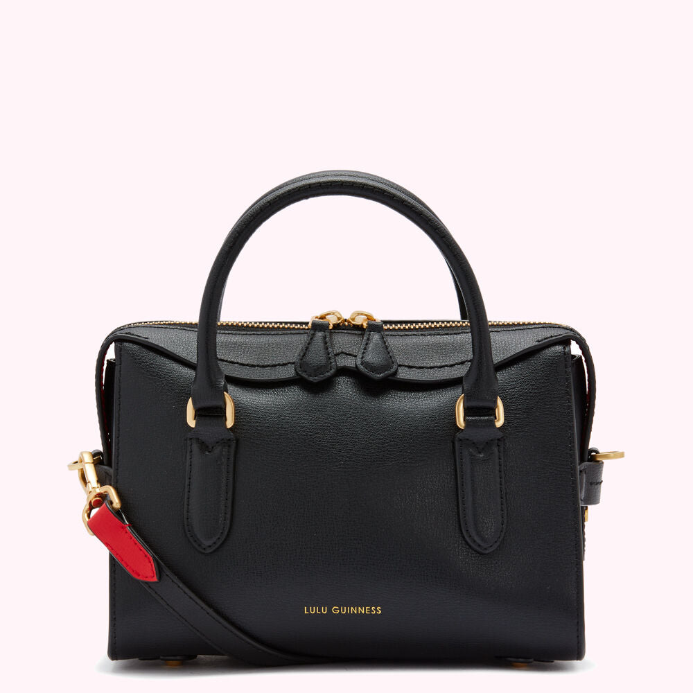 Black Lulu Guinness leather satchel with gold hardware and a red and black strap.