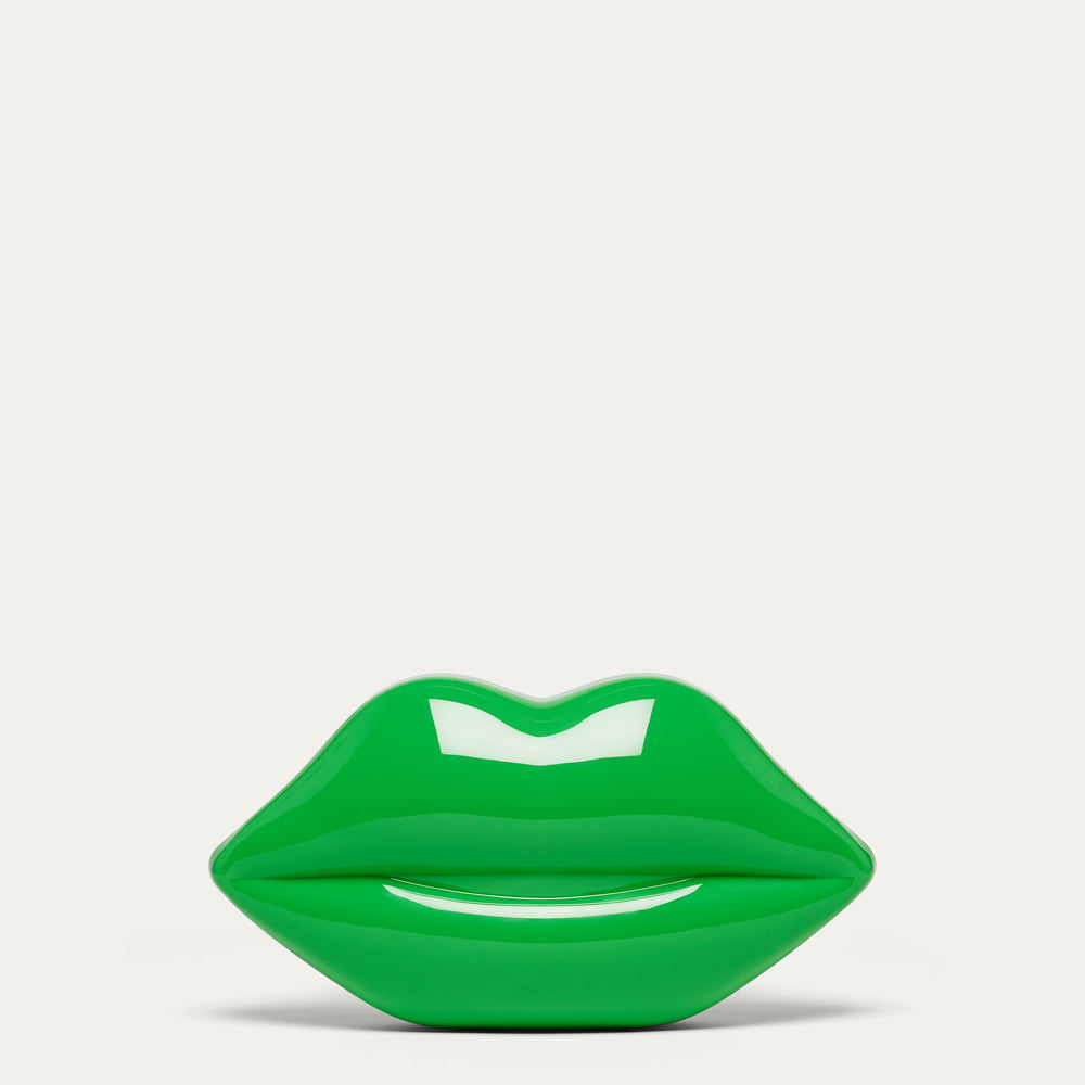 A glossy bright green lips-shaped clutch bag against a clean off-white background.