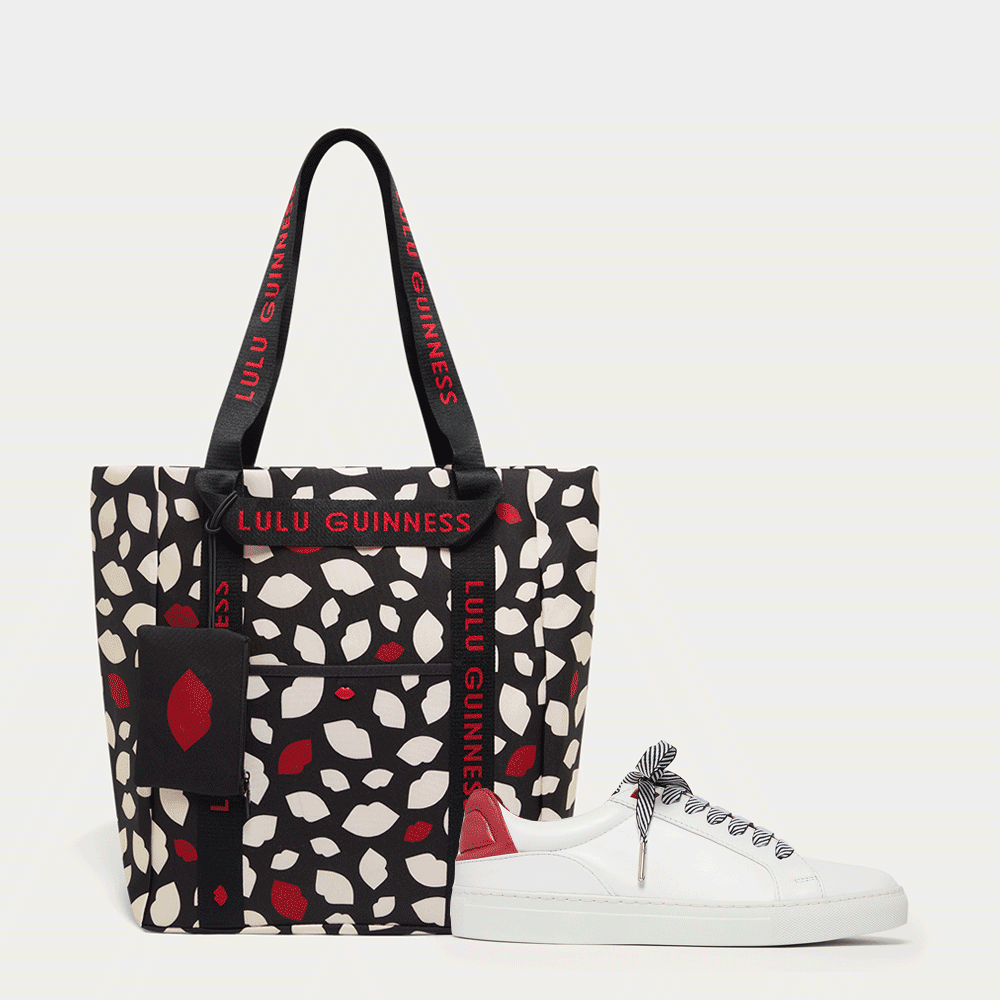 Lip print tote bag with 'Lulu Guinness' branding on the strap with a white trainer with red accents and striped laces