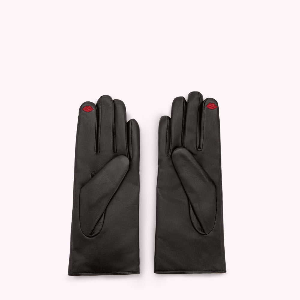 A pair of black leather gloves with a small red lip embroidered on each index finger.