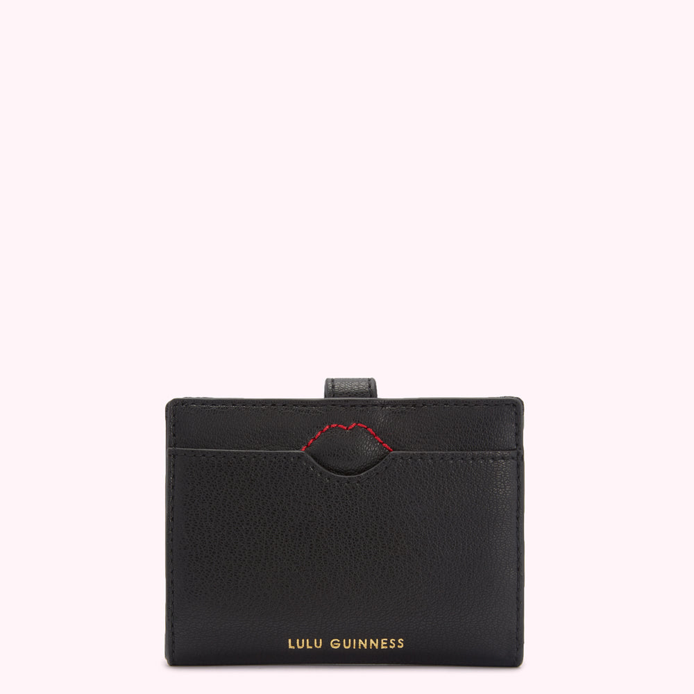 Black Lulu Guinness cardholder with red stitching detail.
