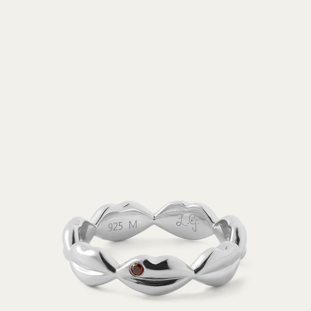 Silver ring with a red gemstone on a white background