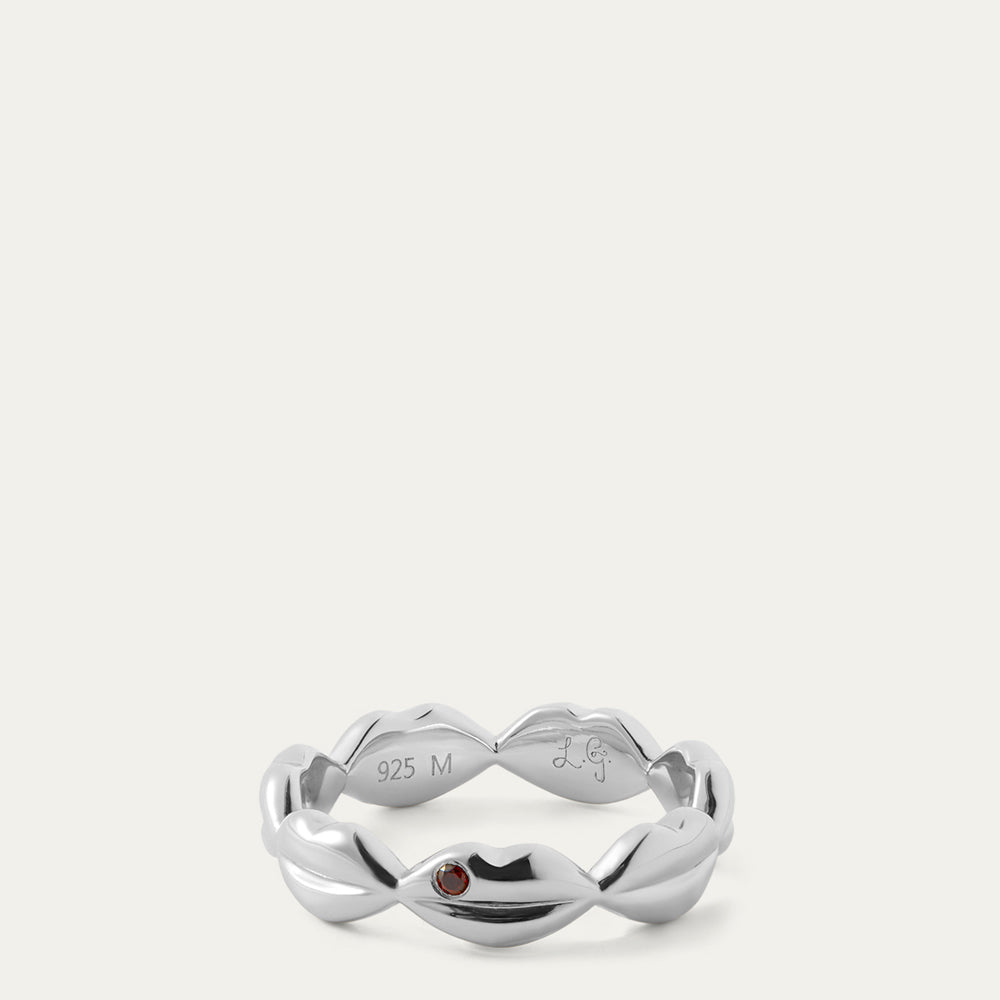 Silver ring with a red gemstone on a white background