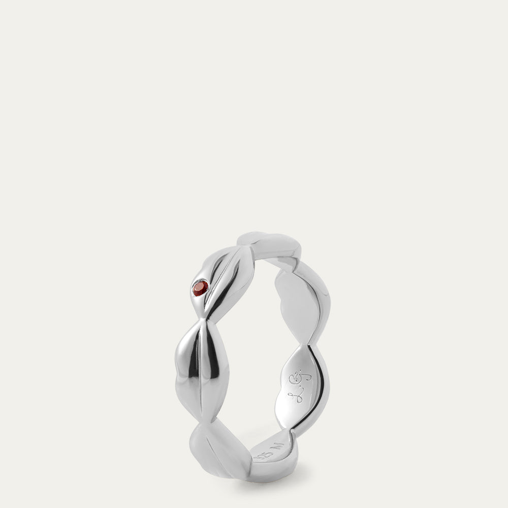 Silver ring with a red gemstone on a white background