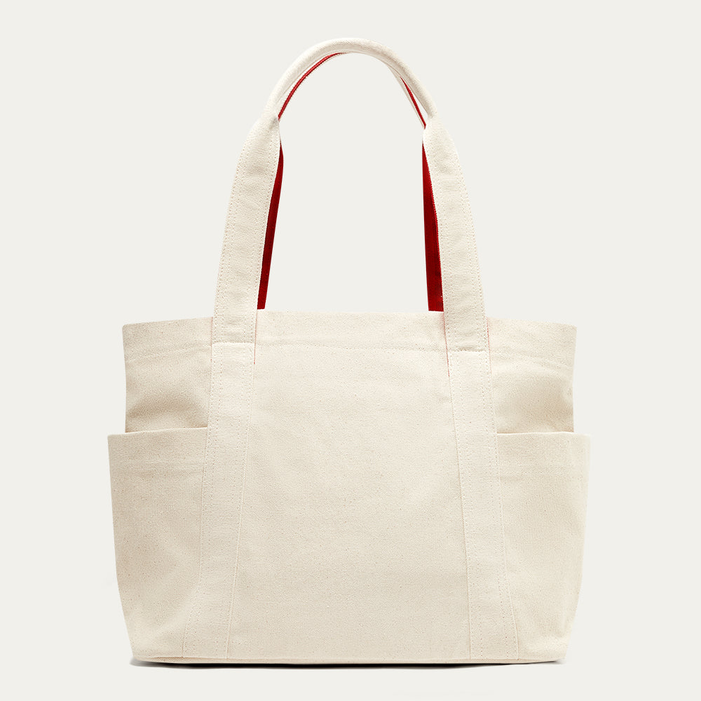 Beige tote bag with red handles on a white background