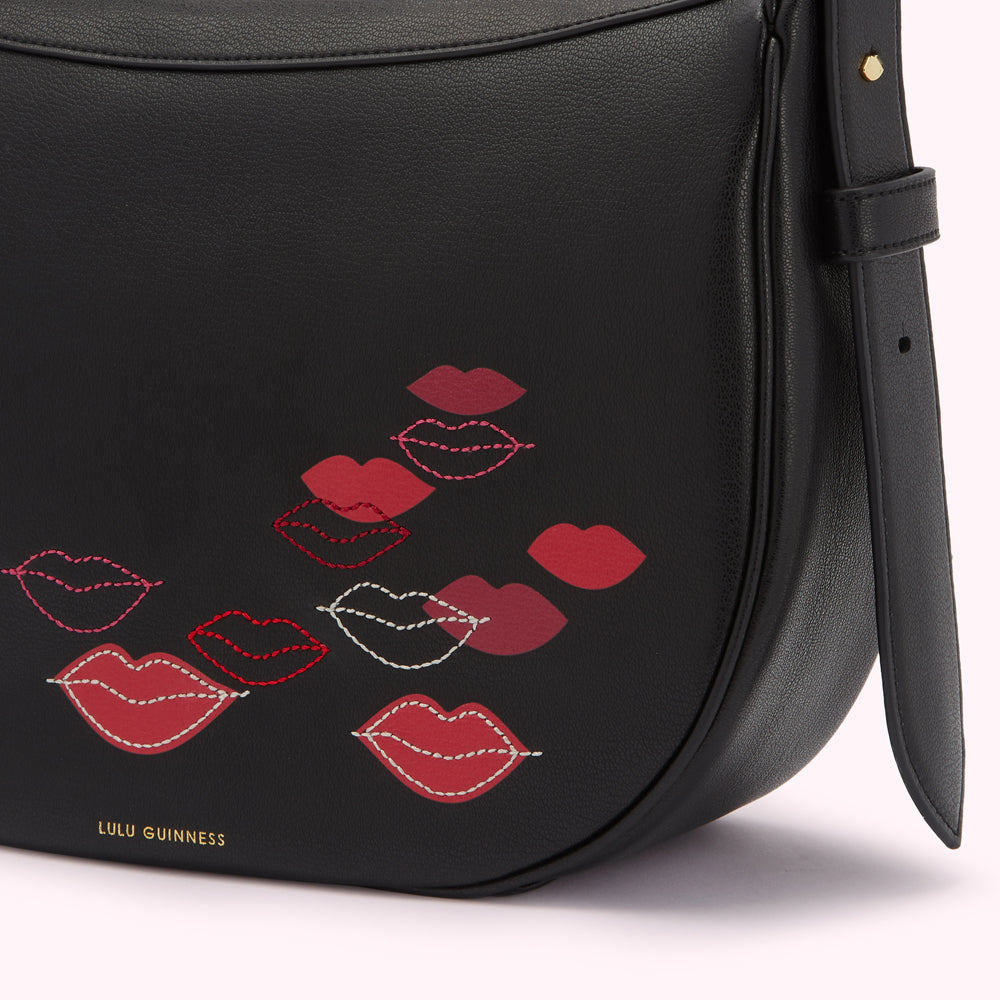 Close-up of a black Lulu Guinness handbag with a lip print design.
