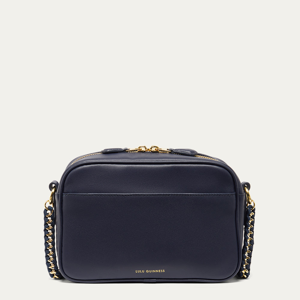 Navy blue leather handbag with gold chain detail on a light grey background
