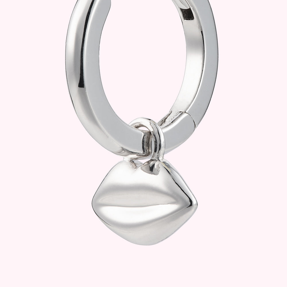 Close up image of a sterling silver hoop earring with lip charm.