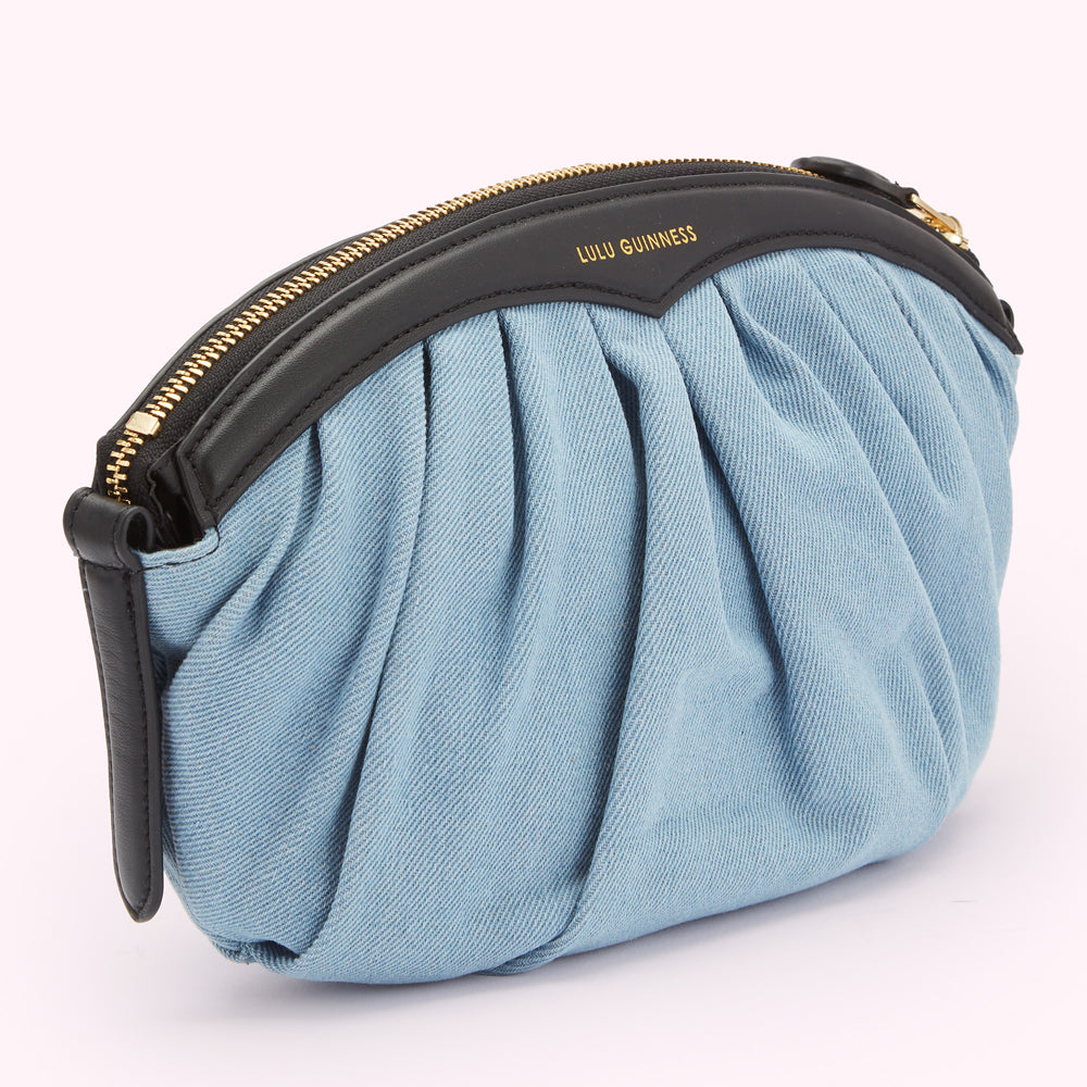 Light blue denim Lulu Guinness clutch with a black leather top and gold zipper.