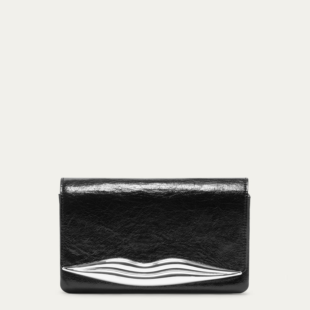 A black leather clutch bag with a glossy finish and a silver metallic lips-shaped accent at the bottom, shown against a light off-white background.