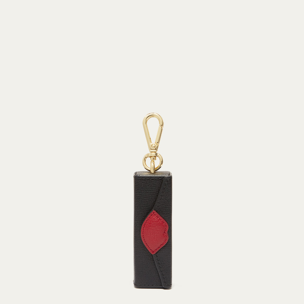 Black and red keychain with gold clasp on a light grey background