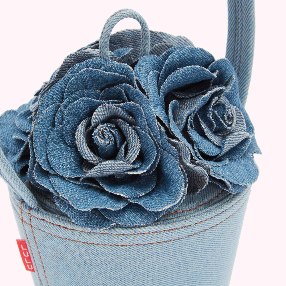 Close-up of a denim handbag adorned with three-dimensional denim roses.
