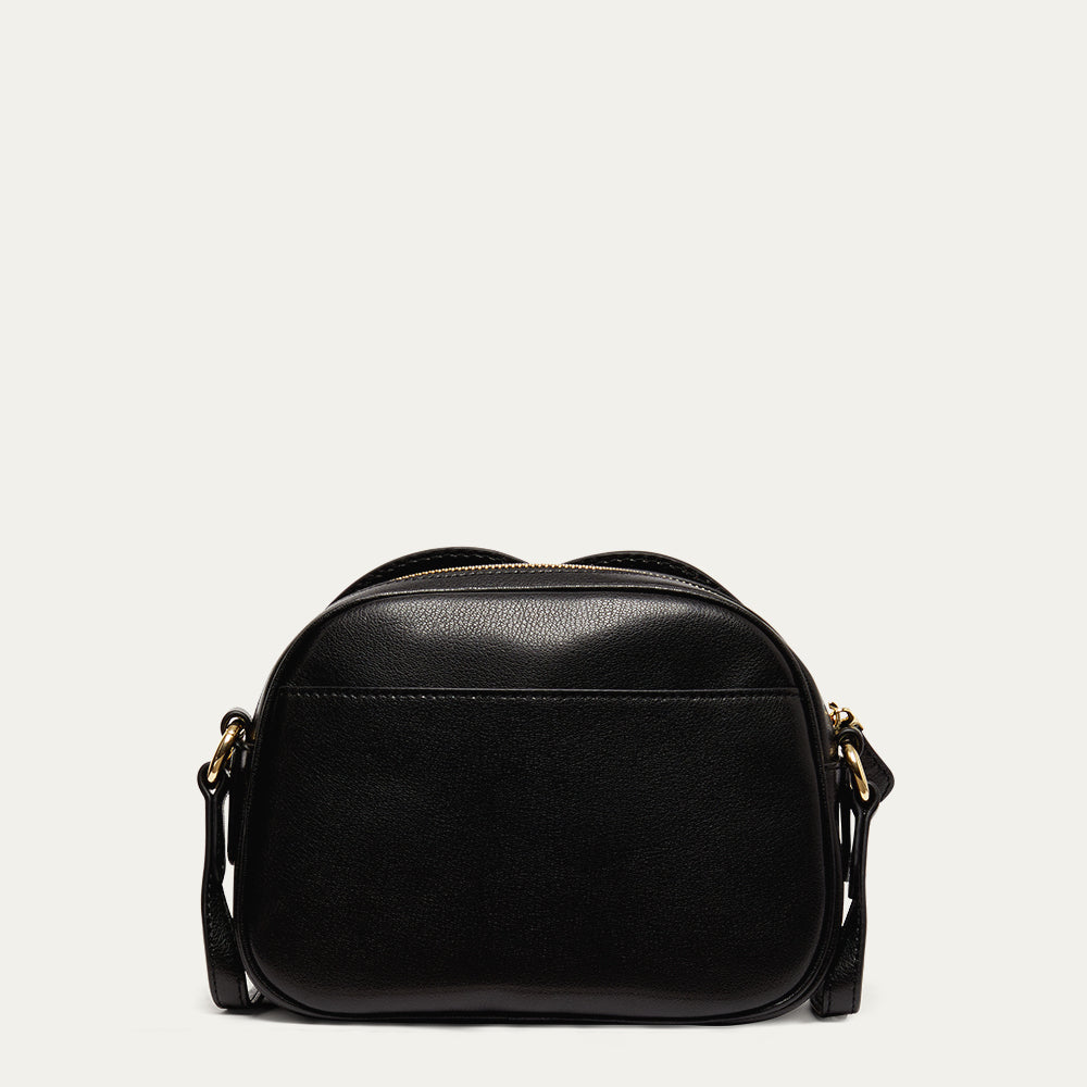 Back image of a black leather crossbody bag on a light grey background revealing the back pocket 
