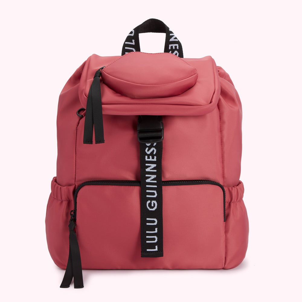 Dusty rose Lulu Guinness backpack with black straps and zipper pulls.
