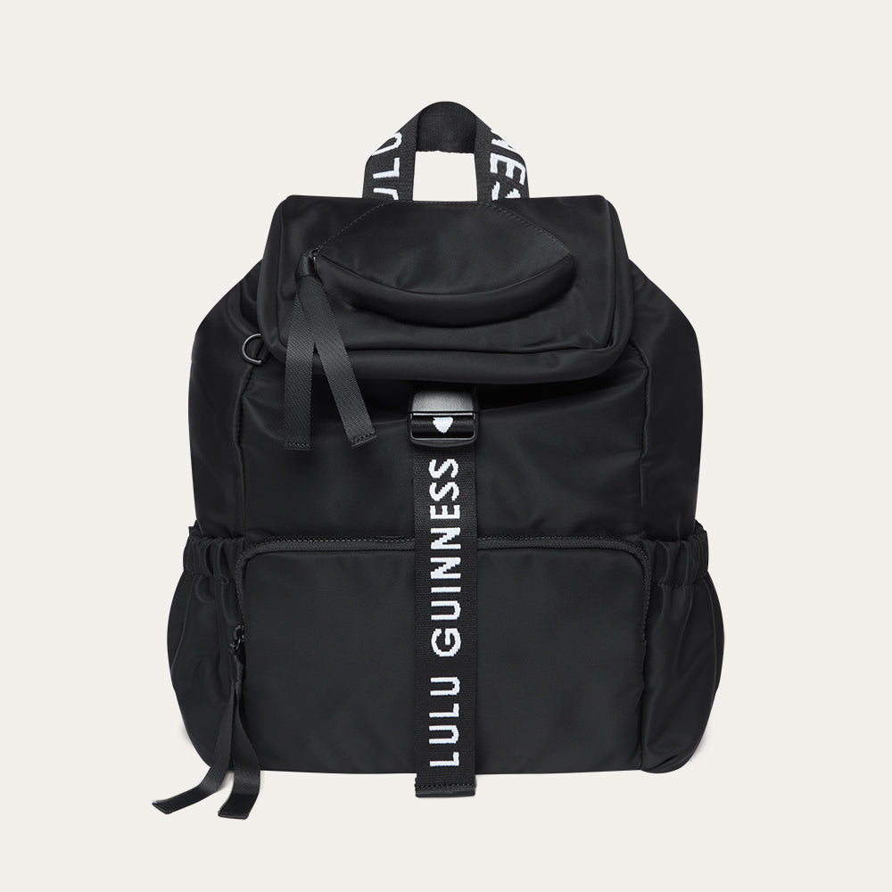 Black backpack with Lulu Guinness strap on a light grey background