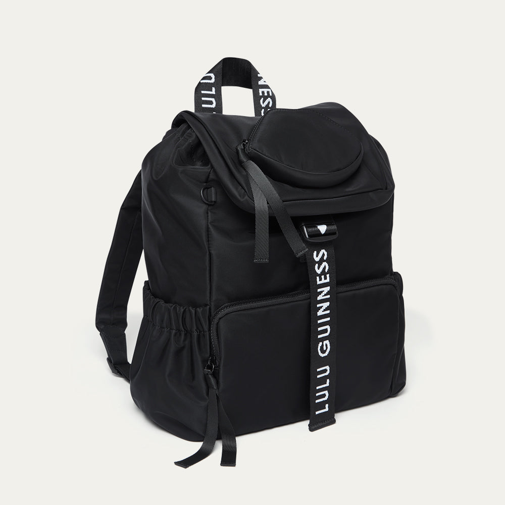 Black backpack with 'Lulu Guinness' branding on a light grey background