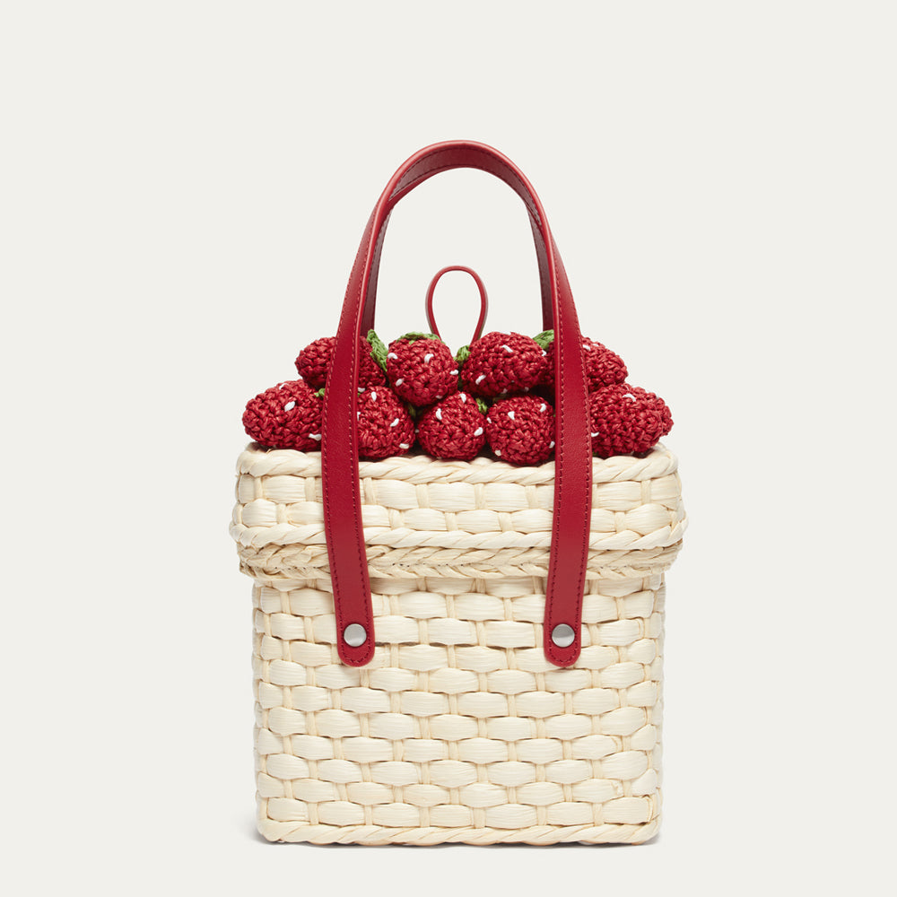 Woven handbag with red handle and strawberry decorations on a white background