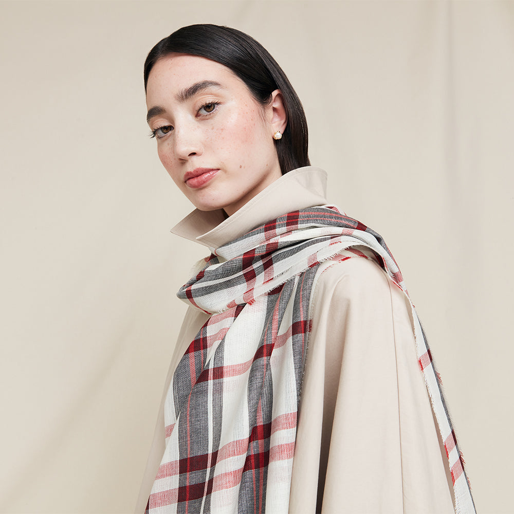 Woman wearing a plaid scarf on a beige background