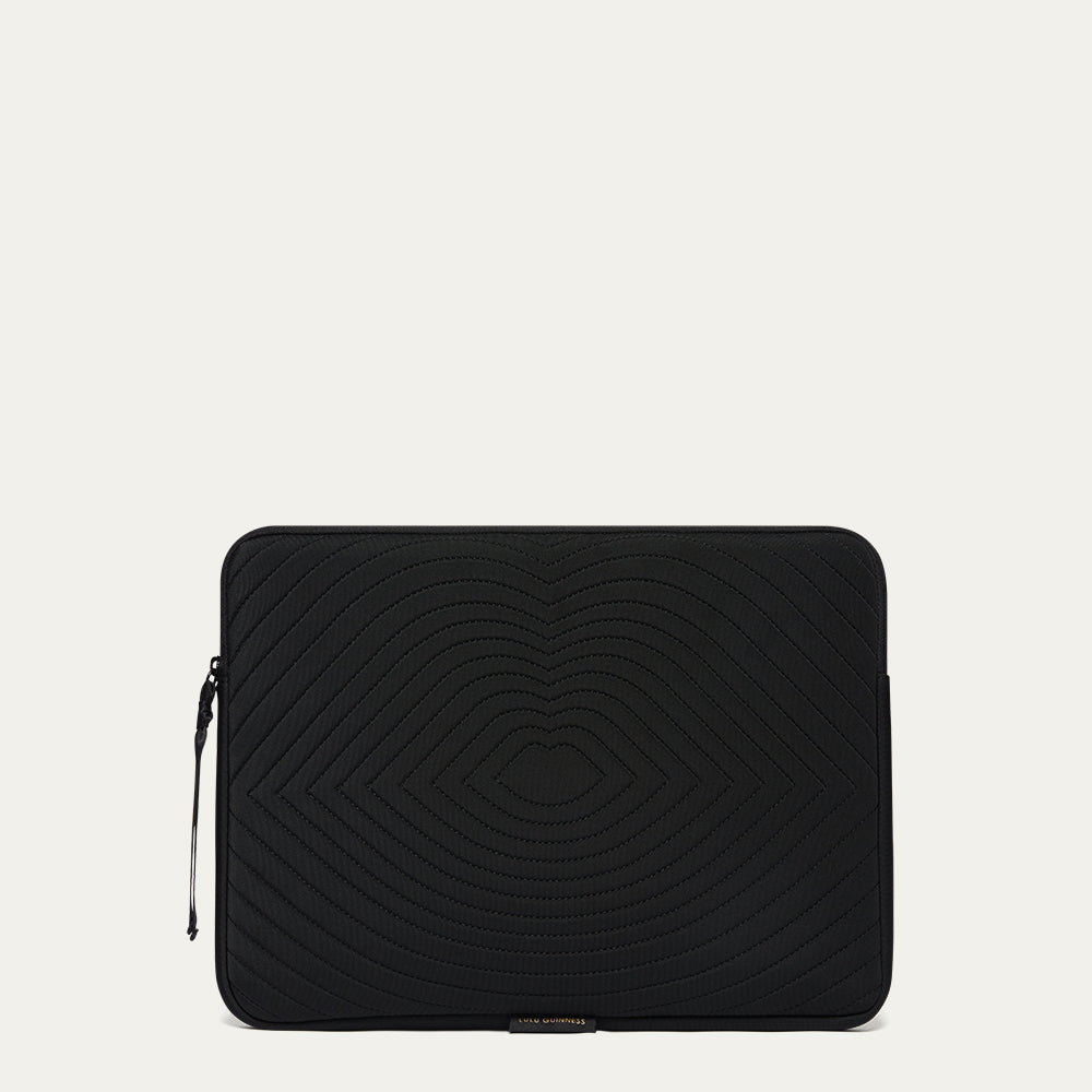 Black laptop sleeve with lip shaped quilting on a light gray background