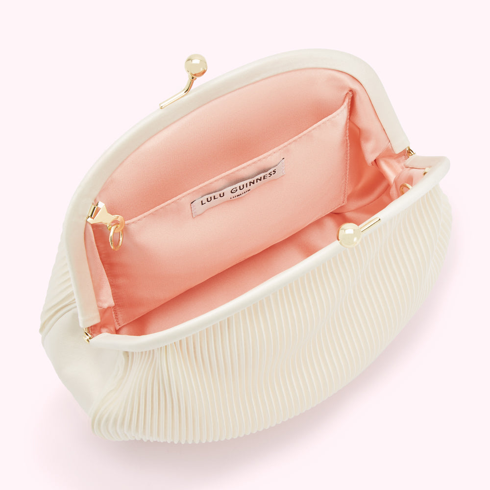Open ivory pleated Lulu Guinness clutch with peach lining.