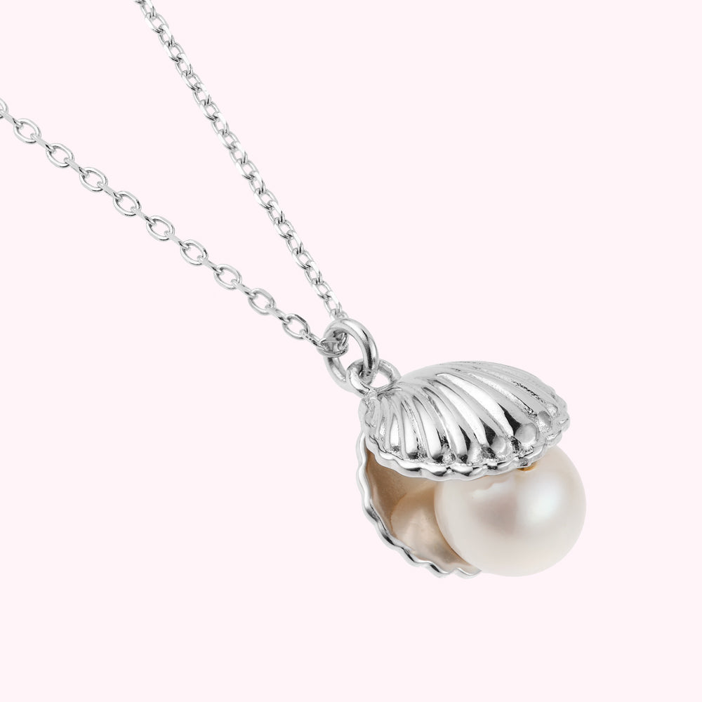 Close up image of a sterling silver shell pendant with a freshwater pearl.