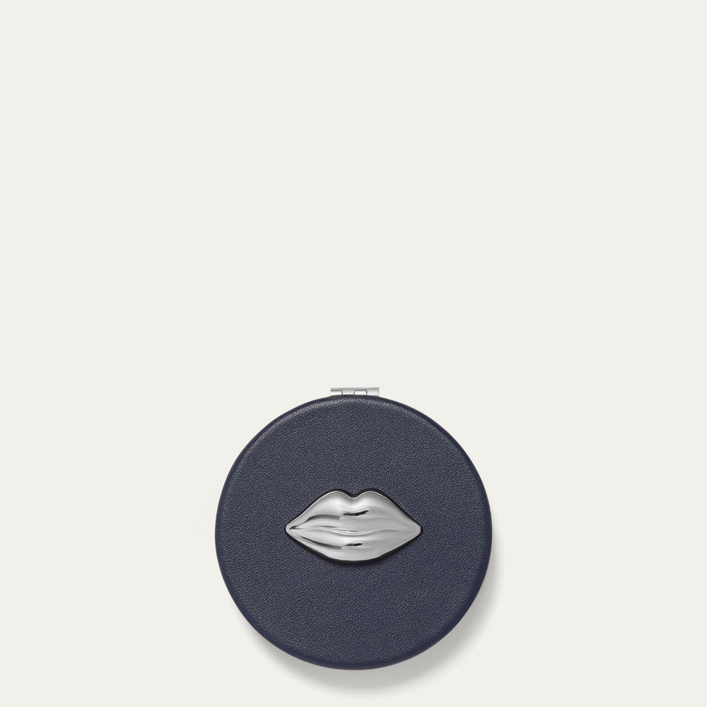 Navy compact mirror with silver lip design on a white background