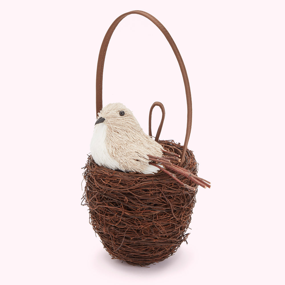 Brown Lulu Guinness bird nest handbag with a beige bird figurine sitting on a brown twig nest with a brown handle.
