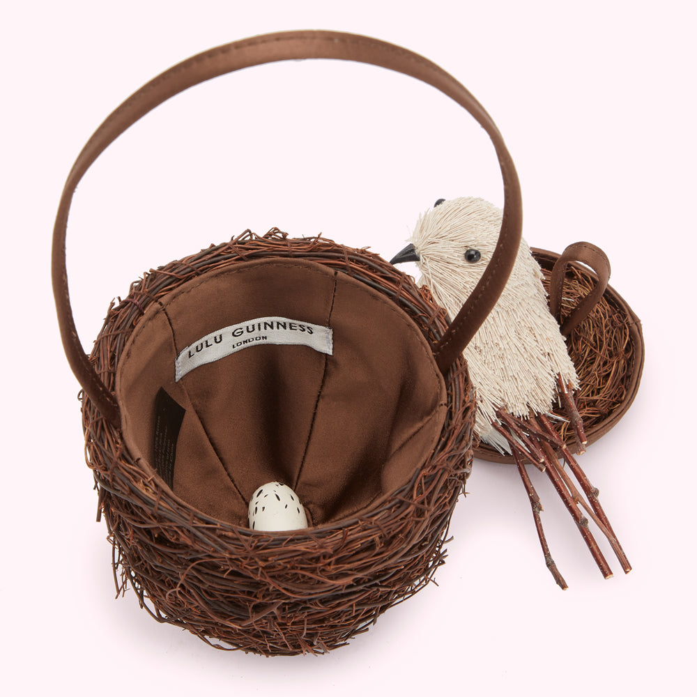 Brown Lulu Guinness bird nest handbag with a small white bird and egg.
