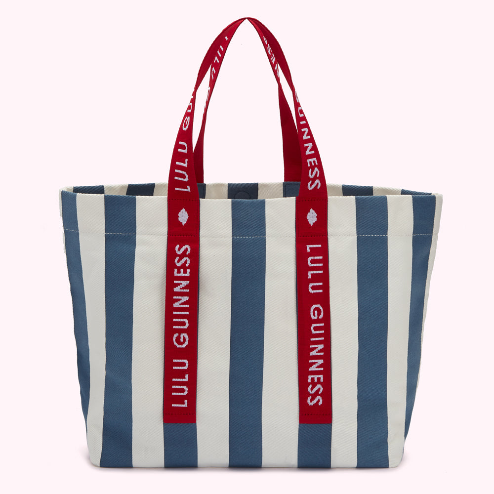 A blue and white striped tote bag with red Lulu Guinness branded straps against a white background.