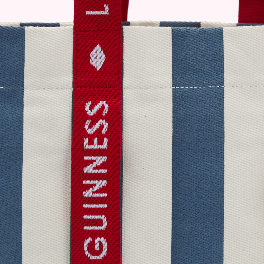 Close-up of a striped tote bag with red "Lulu Guinness" branding on the strap.