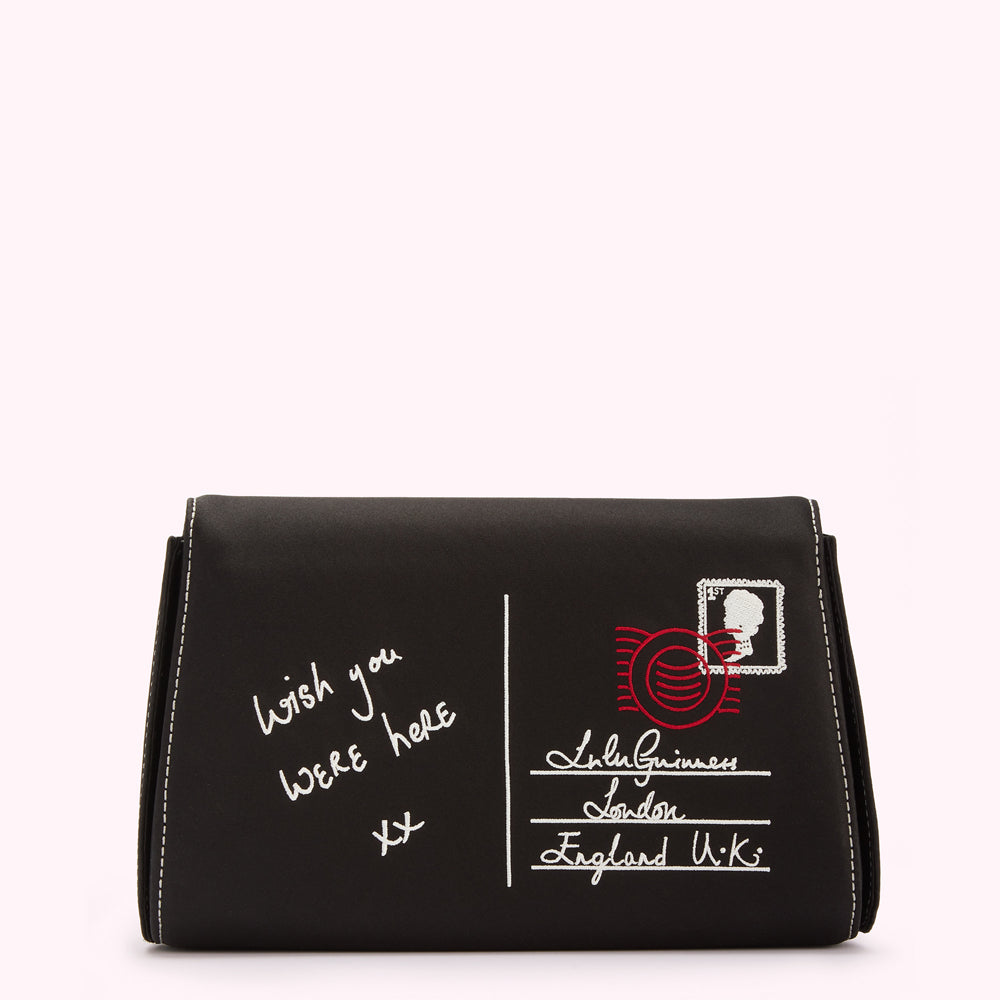Black clutch with white stitching and embroidered postcard design. The postcard features the message "Wish you were here xx" and an address reading "Lulu Guinness London England UK".
