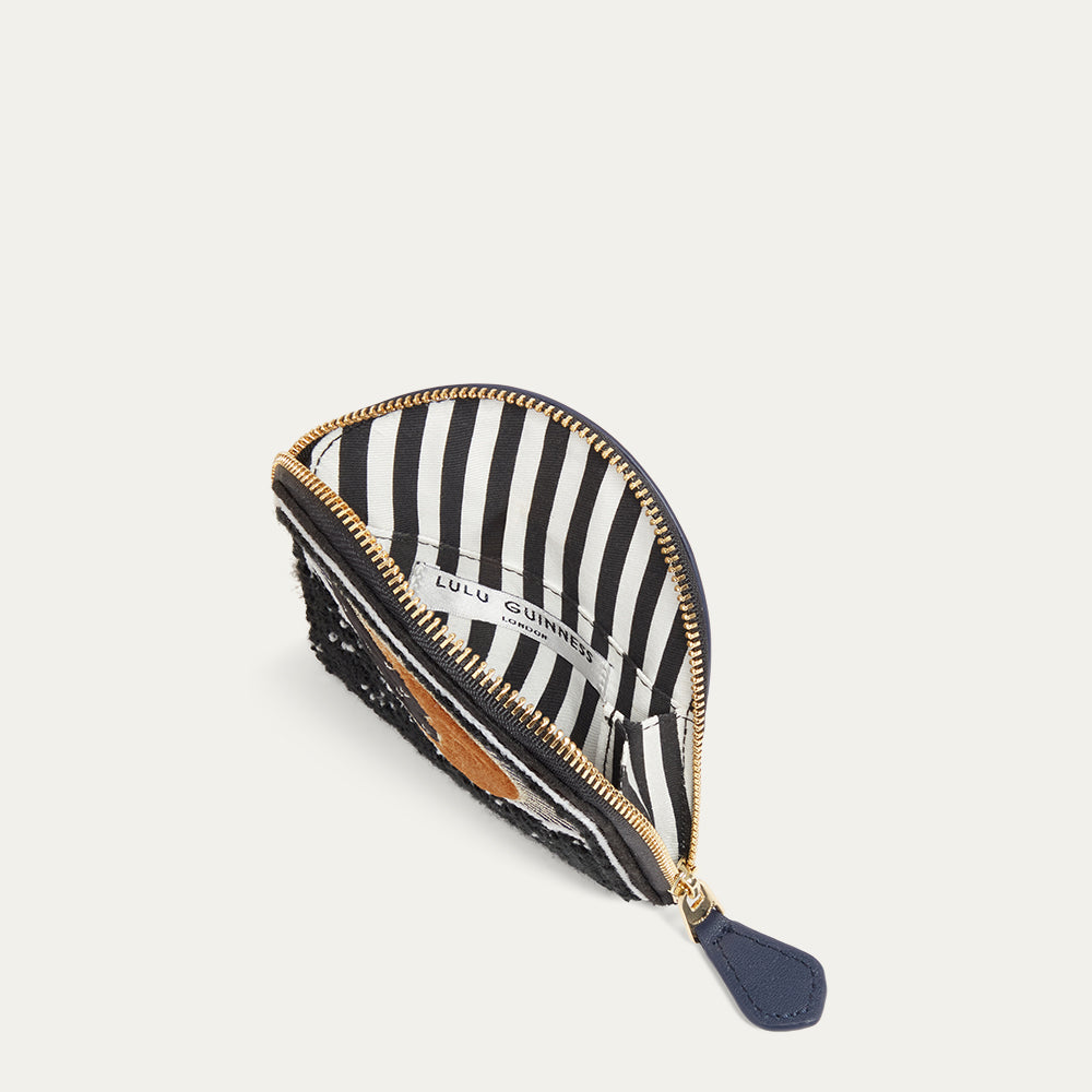 Navy coin purse open to reveal a black and white striped lining with gold zipper on a white background