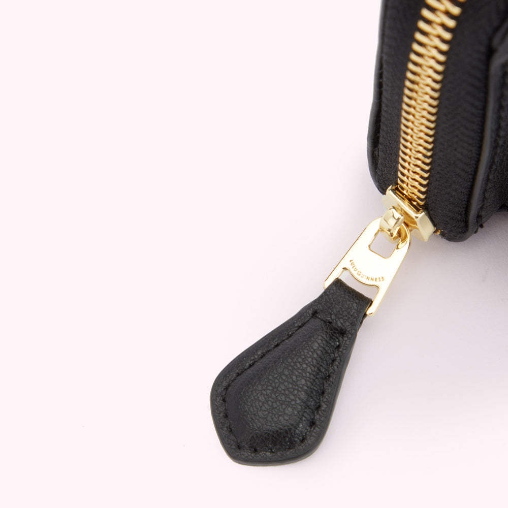 Detail image of a leather zip pull with engraved 'Lulu Guinness' logo.