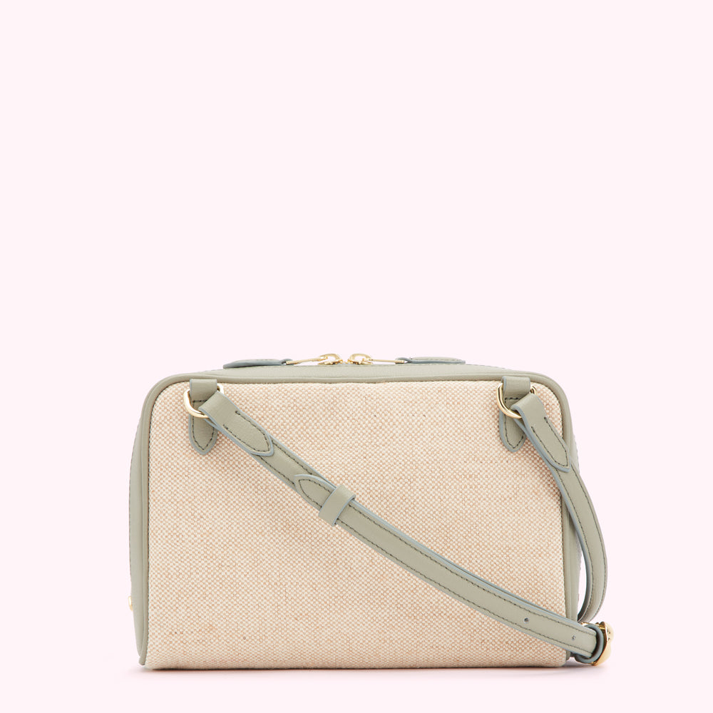 Beige and sage green crossbody bag with a textured fabric body and leather trim.
