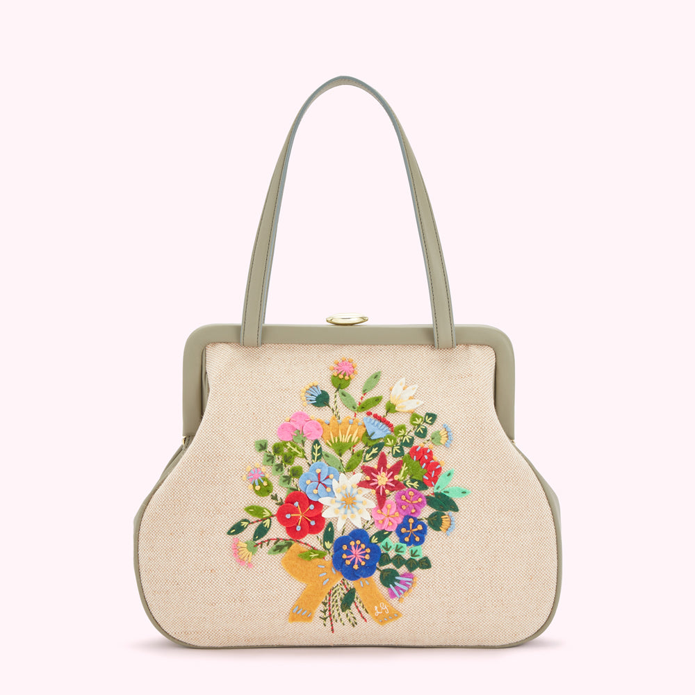 Beige handbag with sage green trim and embroidered floral bouquet.