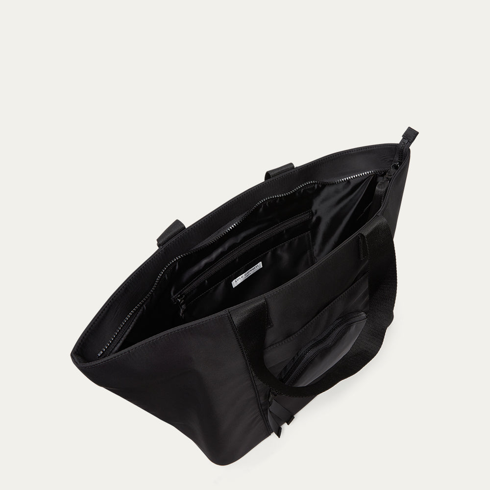 Black bag with open front compartment on a light grey background