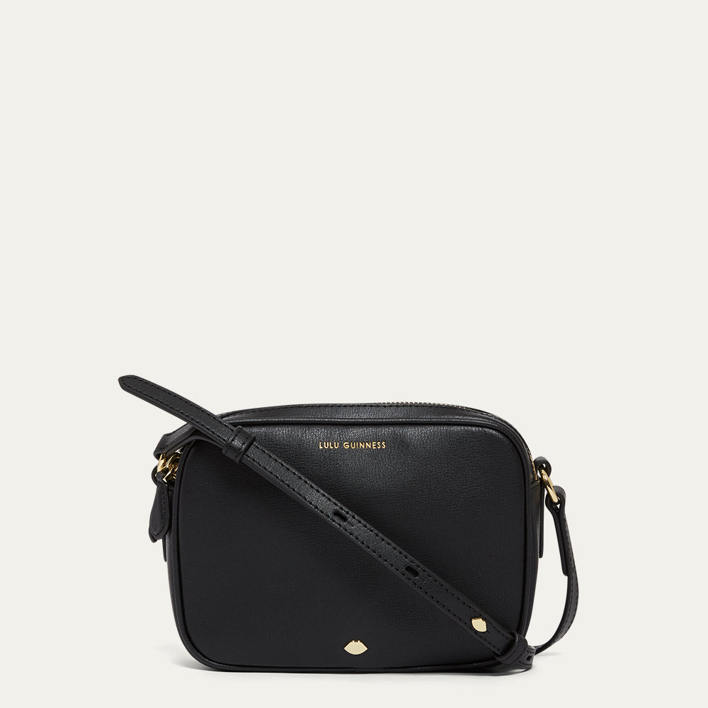 Black handbag with gold accents on a light grey background