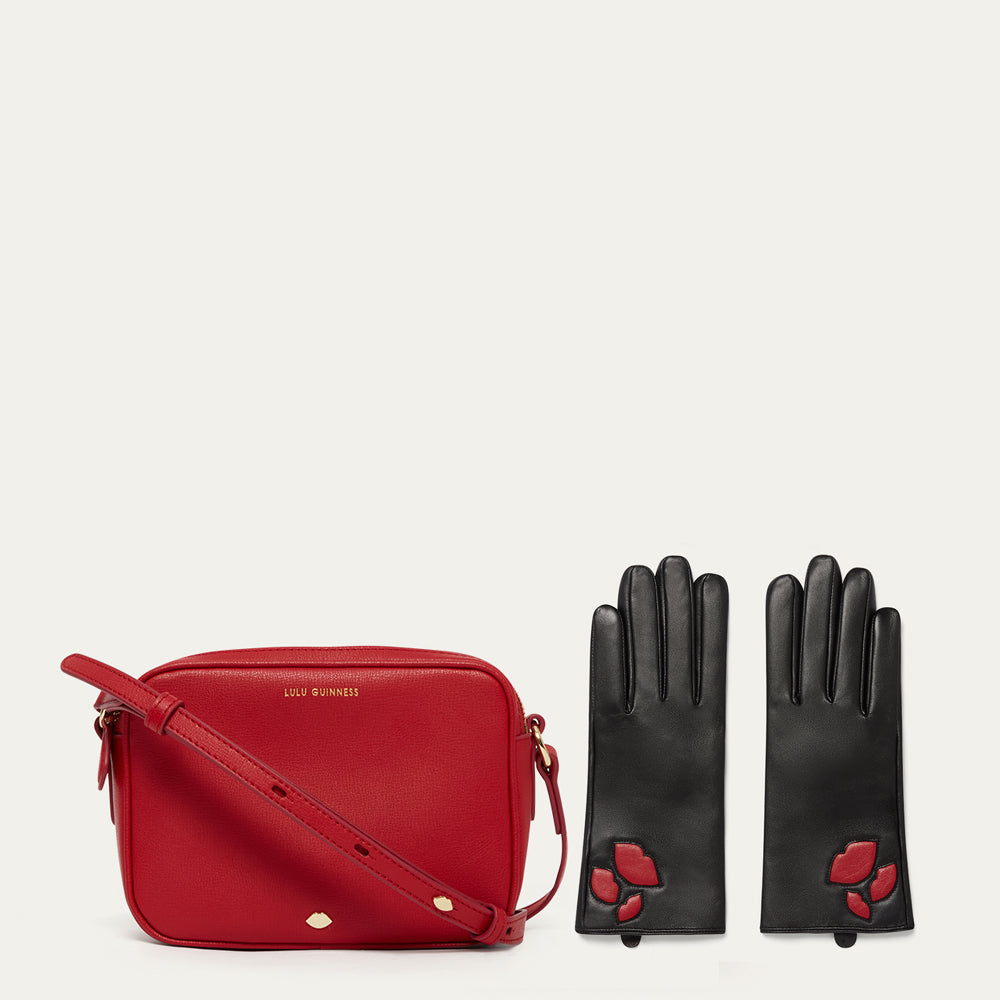 Red handbag and black gloves with red accents on a white background