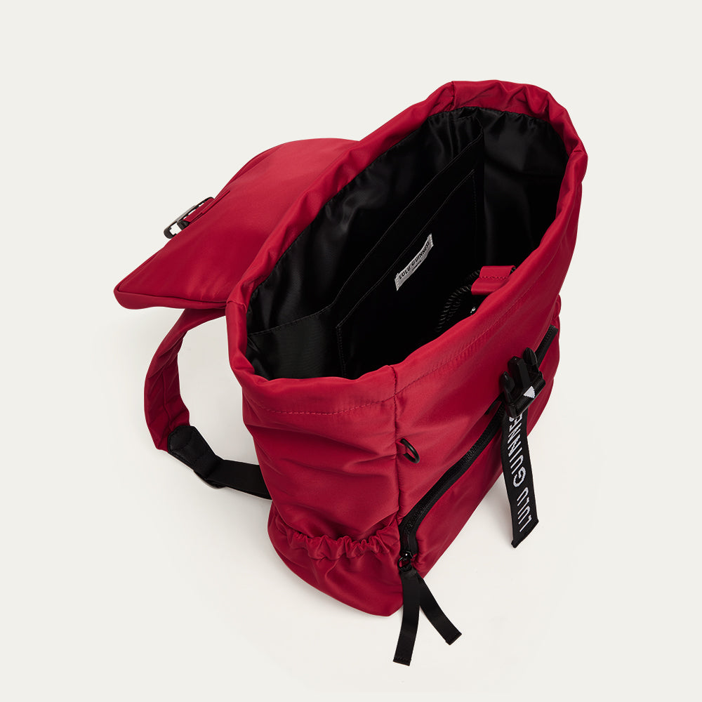 Red backpack open to show a black lining on a white background