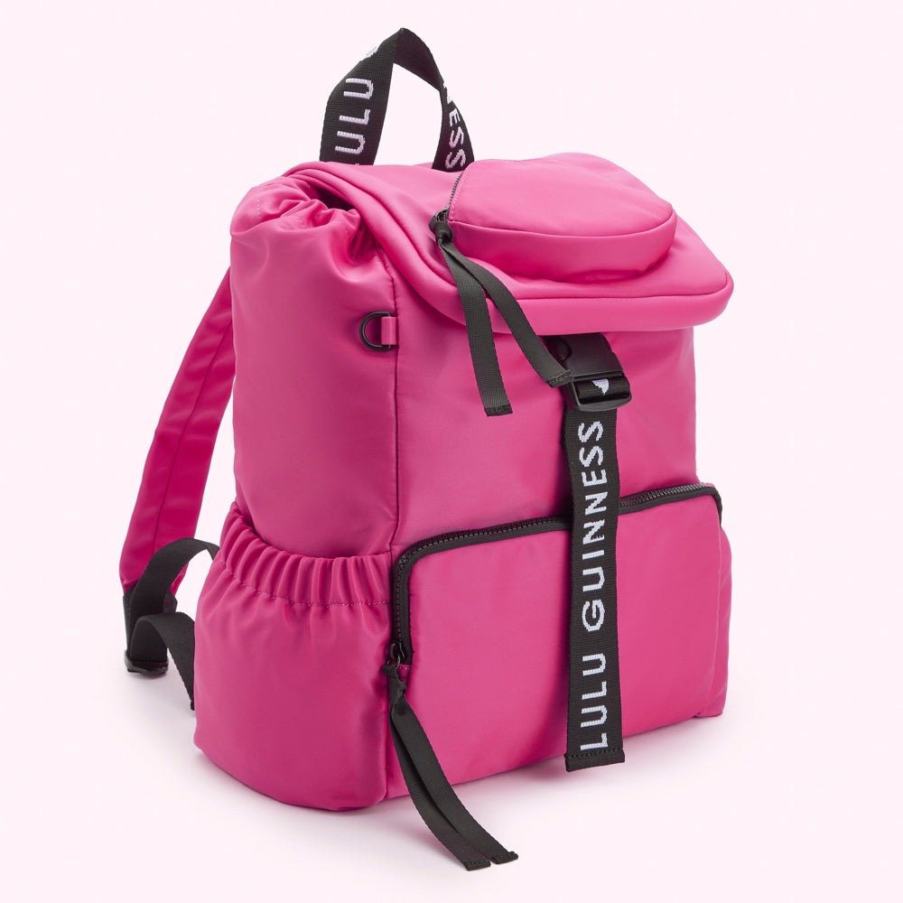 Bright pink Lulu Guinness backpack with black logo straps.
