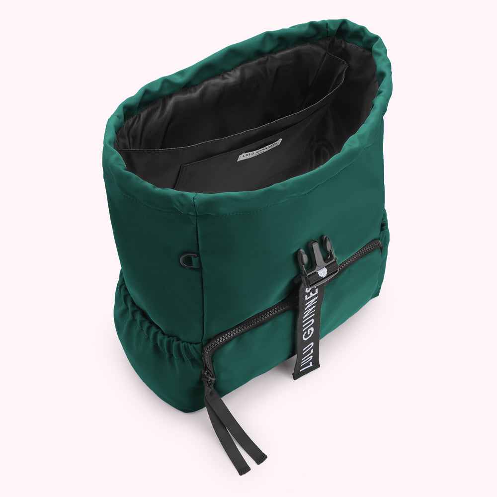 Green Lulu Guinness backpack with black logo detail, viewed from above, showing the inside of the bag.