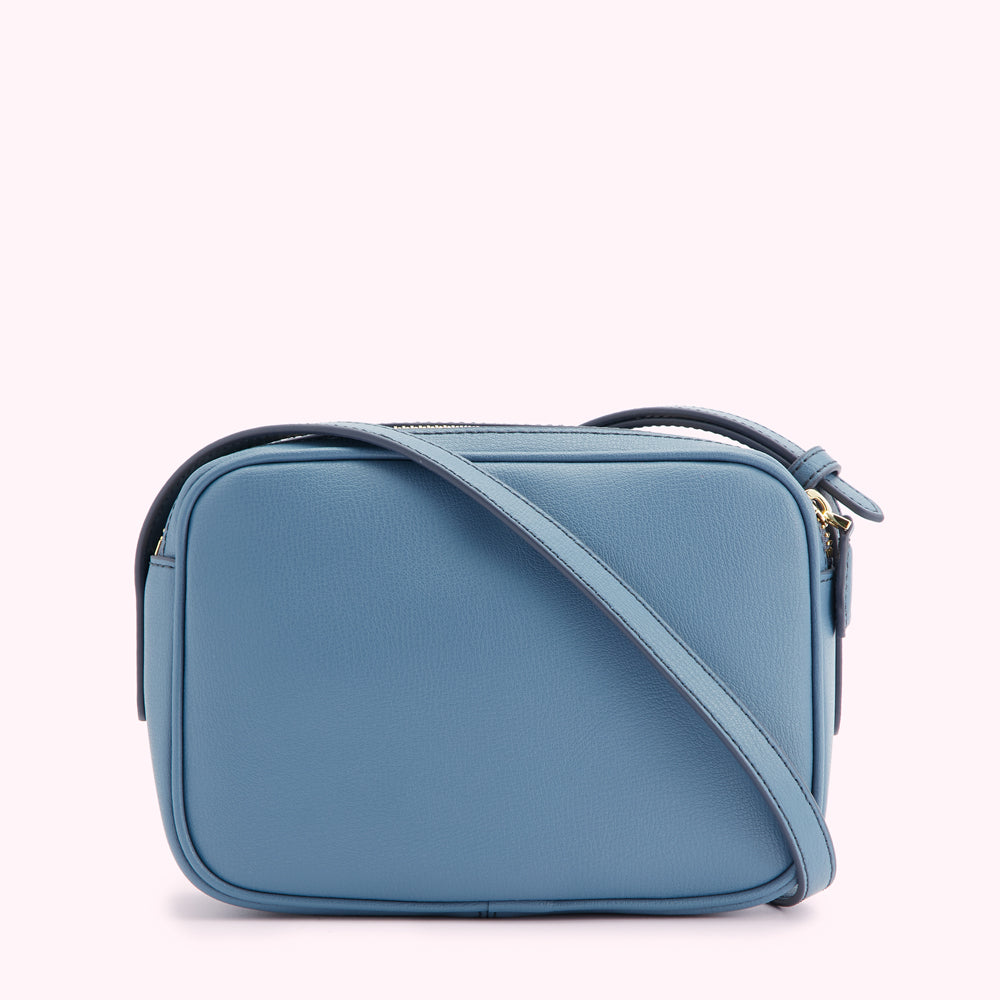 Dusty blue leather crossbody bag with gold zipper.
