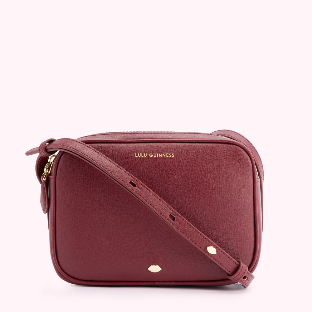 Burgundy Lulu Guinness crossbody bag with gold-toned hardware.
