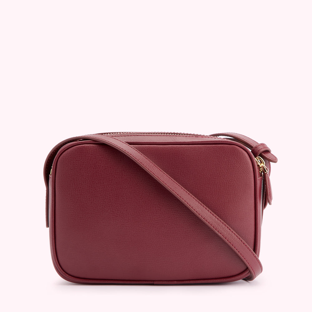 Burgundy leather crossbody bag with gold zipper and strap.

