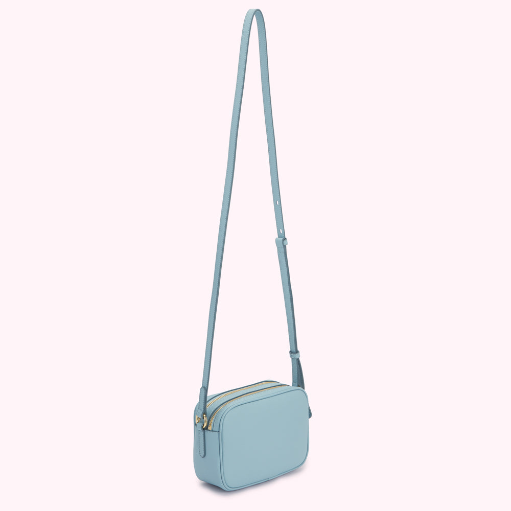 Light blue leather crossbody bag with gold zippers.